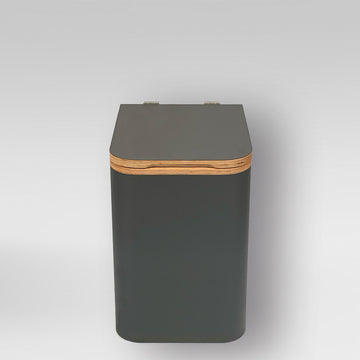 Komposttoilette aus anthrazitfarbenem Holz mit naturfarbenem Rand und abgerundeten Ecken.