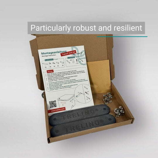 Offene Verpackung mit zwei schwarzen Trelino® Griffen aus Kunststoff und Montageanleitung.
