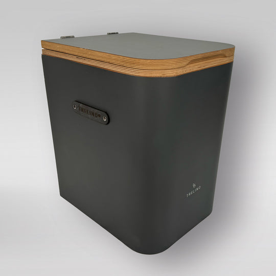 Schwarzes Griffset an Trenntoilette mit Holzdeckel und abgerundeten Kanten.