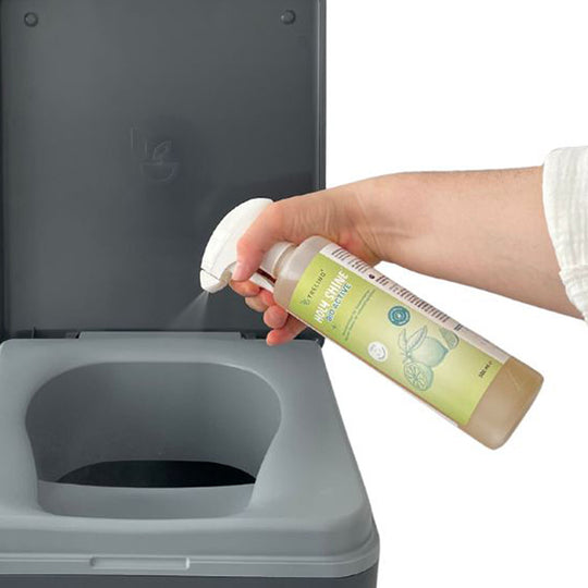 Hand sprüht Trelino® Citrusreiniger Holy Shine auf Trelino® Evo Trenntoilettensitz.