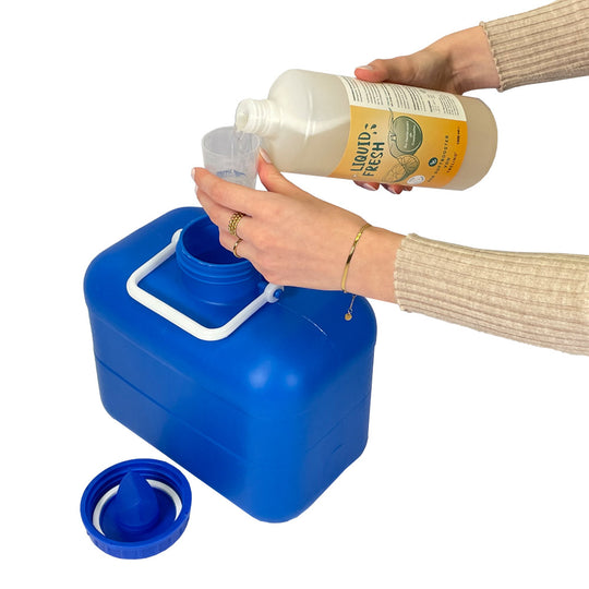 Hände füllen Liquid Fresh im Messbecher ab für den Urinkanister.