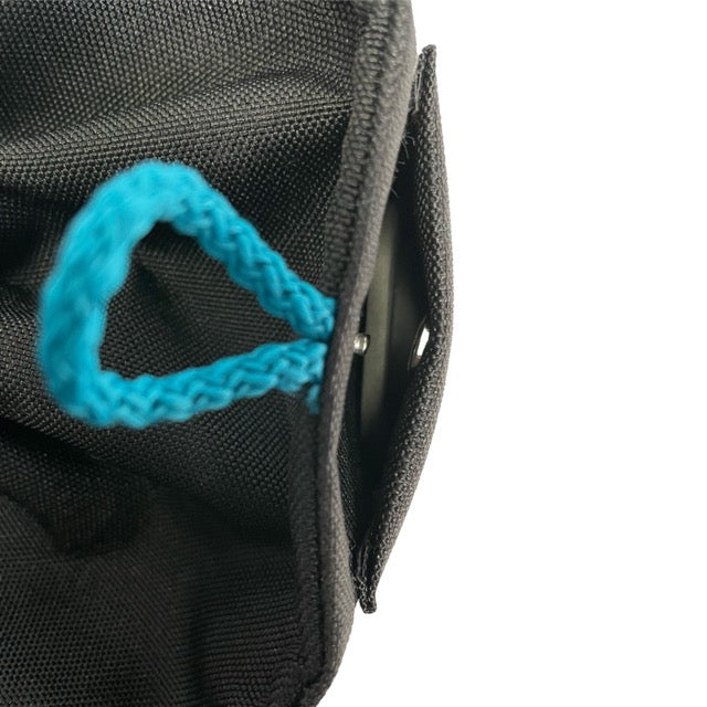 Schwarzer Stoffbehälter mit blauem Trageschlaufe und Magnetverschluss am Rand.