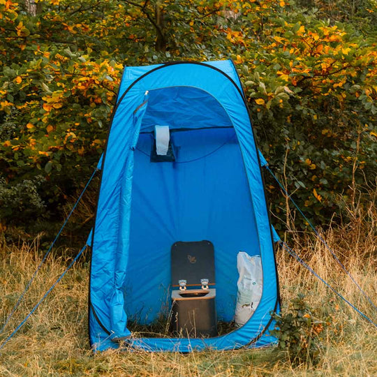 Blaues Klappzelt für mobile Toilette mit Papierhalter und Trenntoilette drinnen.