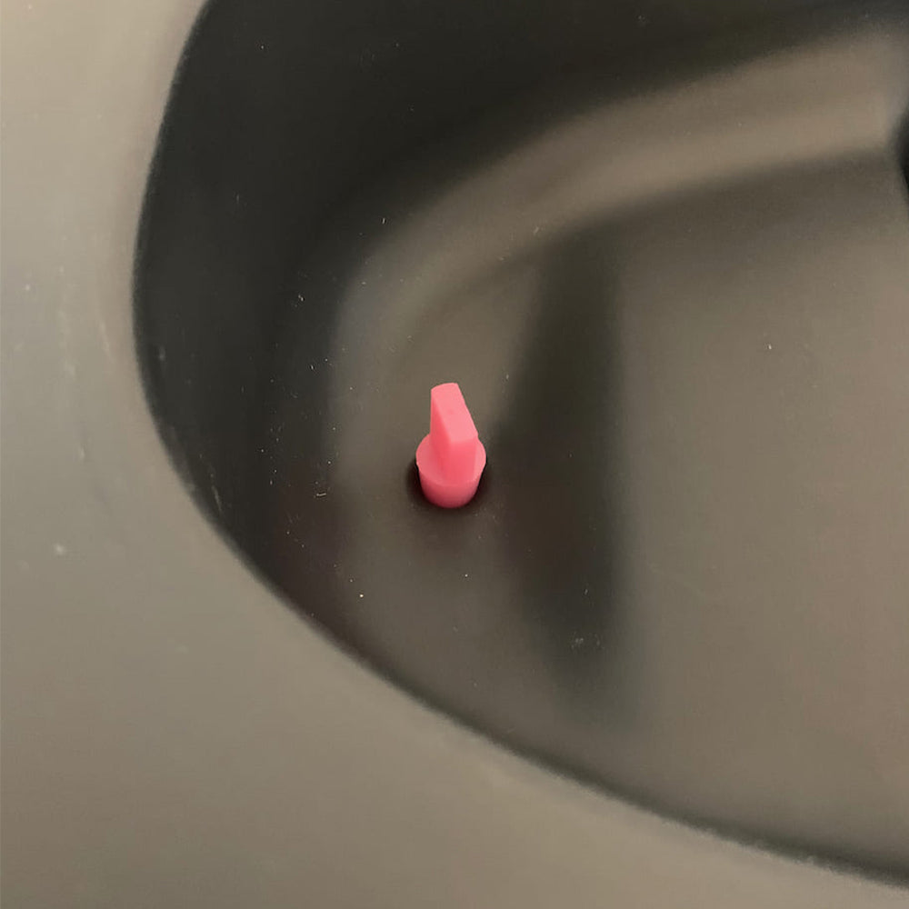 Pinker Stopfen in der Urinöffnung im Trenneinsatz der Trenntoilette.